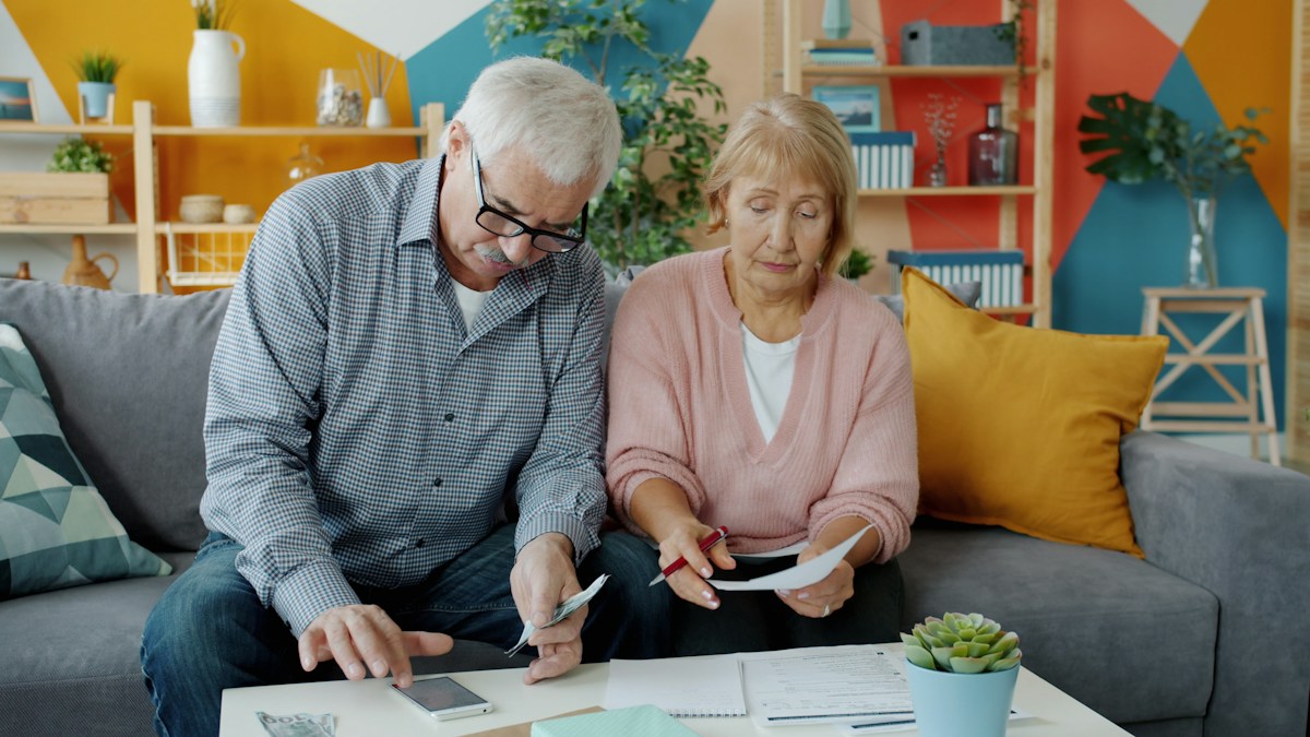 An older couple looking over paperwork together at home
